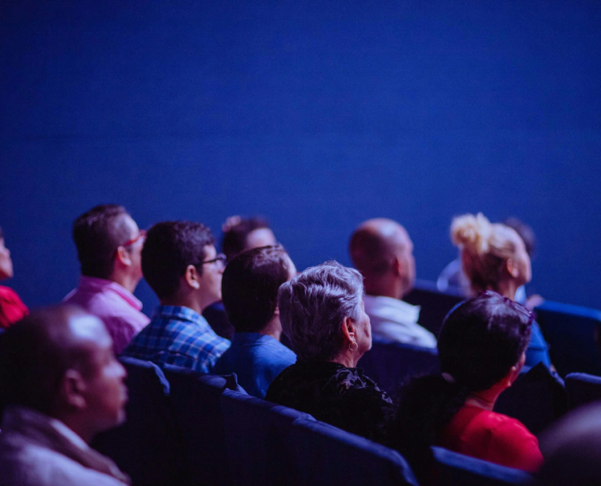 Köpfe von Zuschauern von seitlich hinten in einem Kino