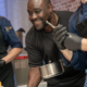 Nelson Müller lächelt beim Kochen mit seinen Kollegen
